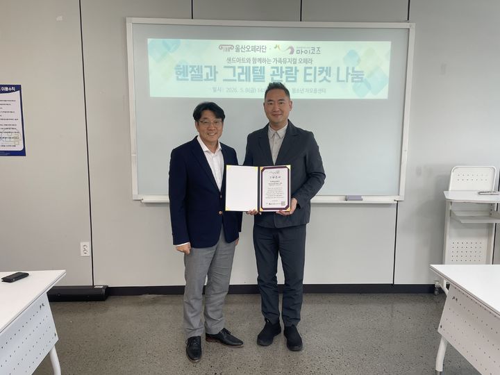 [울산=뉴시스]  8일 울산문화예술 대공연장에서 울산오페라단 천영진 대표가 마이코즈 예동열 이사장에게 청소년들을 위한 가족뮤지컬 오페라 '헨젤과 그레텔' 공연 관람 티켓을 전달하고 있다. (사진=마이코즈 제공) 2026.05.08. photo@newsis.com *재판매 및 DB 금지
